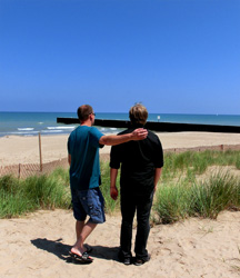 two men standing on a beach