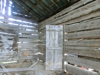 wooden logs with space of chinking, old door, sunlight coming through spaces